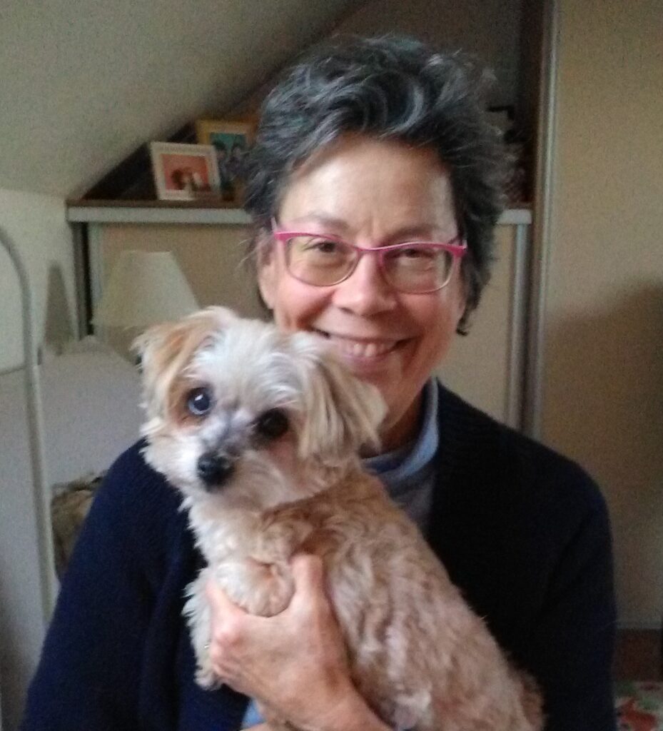 Linda Clément smiliing and holding her dog